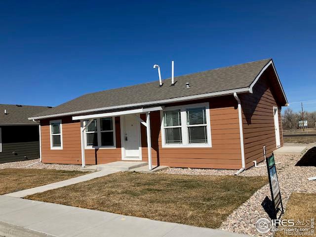 view of front of property with roof with shingles and a front lawn