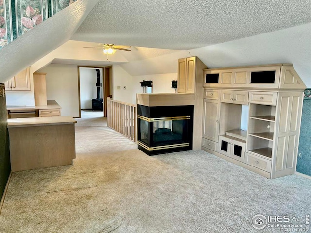 additional living space featuring light carpet, a textured ceiling, and lofted ceiling