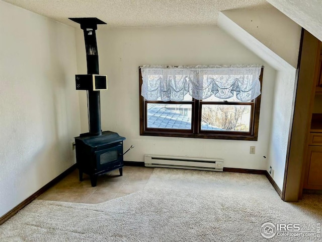 interior space with baseboard heating, a wood stove, light carpet, a textured ceiling, and baseboards