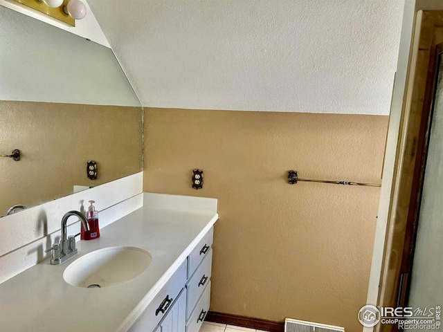 bathroom with visible vents, vaulted ceiling, and vanity