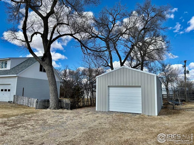 detached garage with fence and driveway