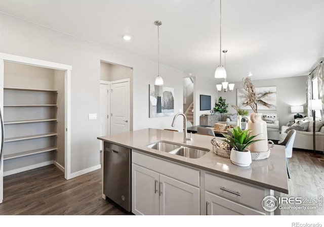 kitchen featuring stainless steel dishwasher, open floor plan, a sink, and dark wood-style flooring