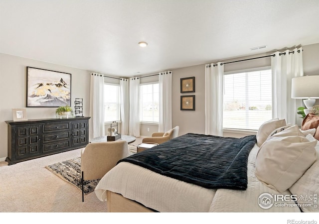 bedroom featuring visible vents, carpet floors, and multiple windows