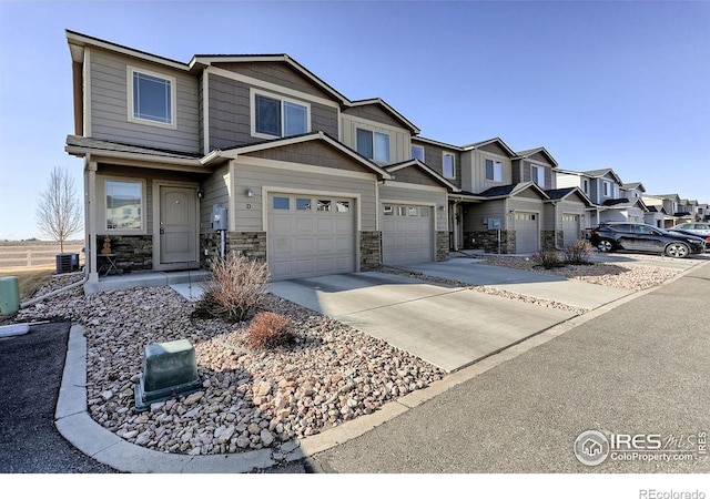 3169 Fairmont Dr Unit 9-D, Wellington, CO 80549 - townhome / multi-family property with an attached garage, central AC, concrete driveway, stone siding, and a residential view