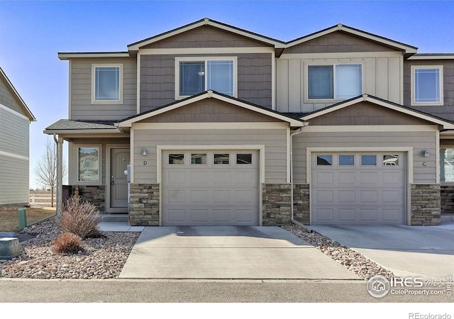 view of front of house featuring an attached garage, stone siding, board and batten siding, and concrete driveway