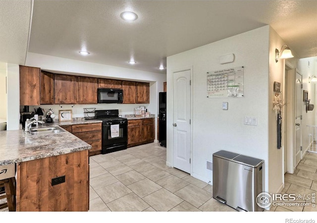 kitchen featuring light tile patterned floors, recessed lighting, light countertops, a sink, and black appliances