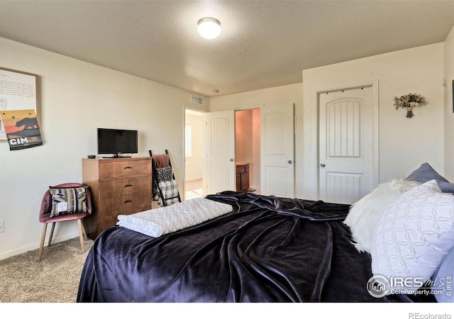 carpeted bedroom with a closet, visible vents, a textured ceiling, and baseboards