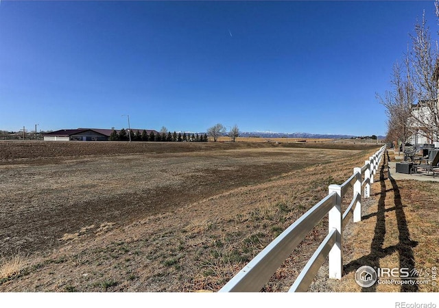 view of yard with a rural view and fence