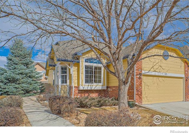 view of front of home featuring a garage, brick siding, driveway, and roof with shingles