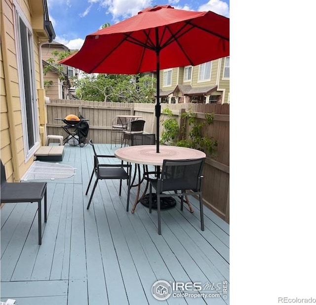 wooden deck with outdoor dining space and fence