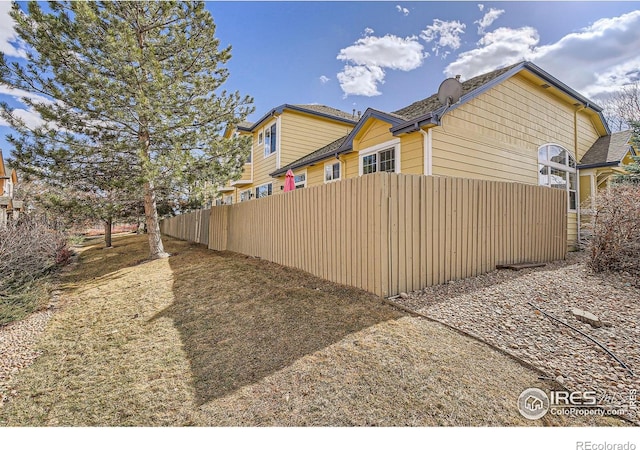 view of side of property featuring fence