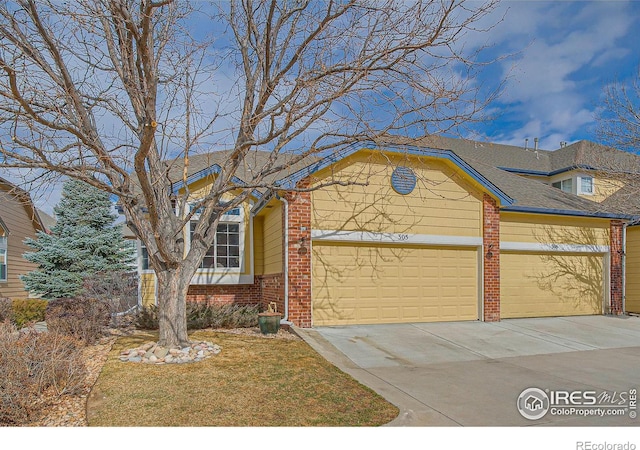 single story home with a shingled roof, concrete driveway, brick siding, and an attached garage