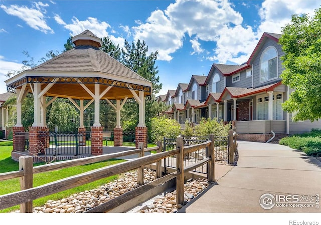 view of property's community with a residential view, fence, and a gazebo