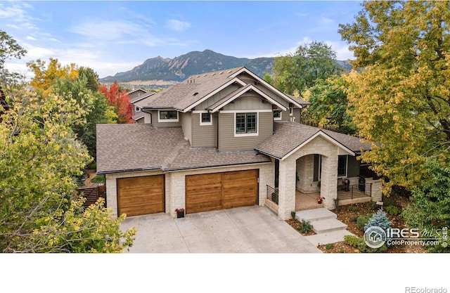 view of front of house featuring board and batten siding, stone siding, covered porch, and a mountain view