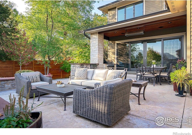 view of patio with outdoor dining area, fence, and an outdoor living space