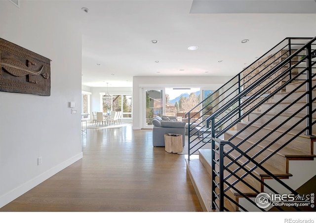 hall with stairway, recessed lighting, wood finished floors, and baseboards