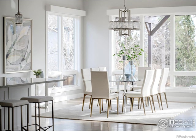 dining space with a chandelier, baseboards, and a healthy amount of sunlight