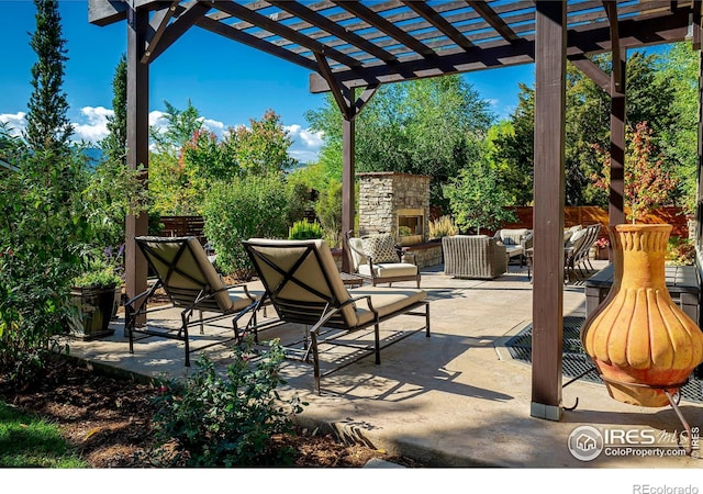 view of patio with fence, an outdoor living space with a fireplace, and a pergola