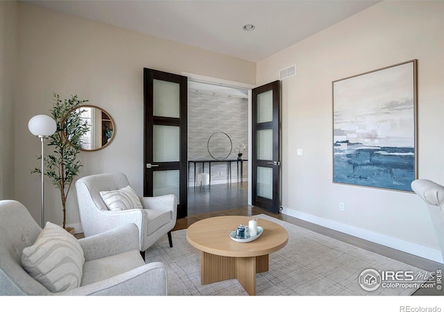 living room with recessed lighting, wood finished floors, visible vents, and baseboards