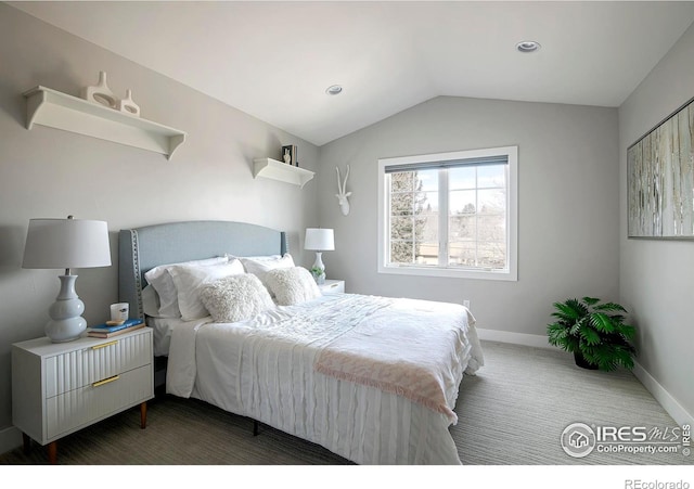 carpeted bedroom featuring lofted ceiling and baseboards