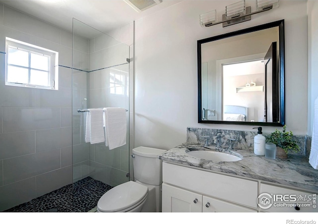 bathroom with visible vents, a shower stall, toilet, and vanity