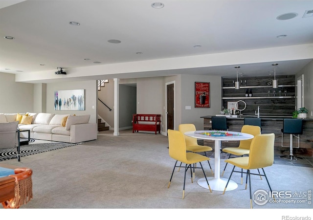 dining room with indoor wet bar, recessed lighting, visible vents, stairway, and light carpet