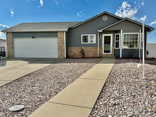 single story home with a garage, driveway, and brick siding