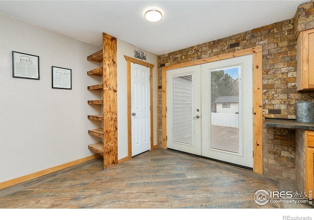 doorway featuring french doors, a textured ceiling, baseboards, and wood finished floors