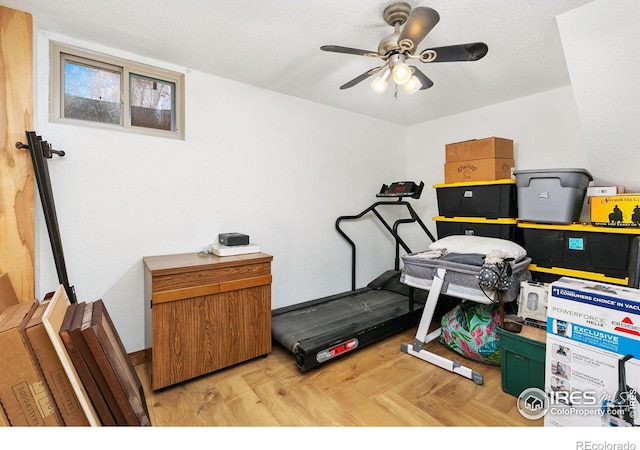 workout room featuring a ceiling fan and a textured ceiling