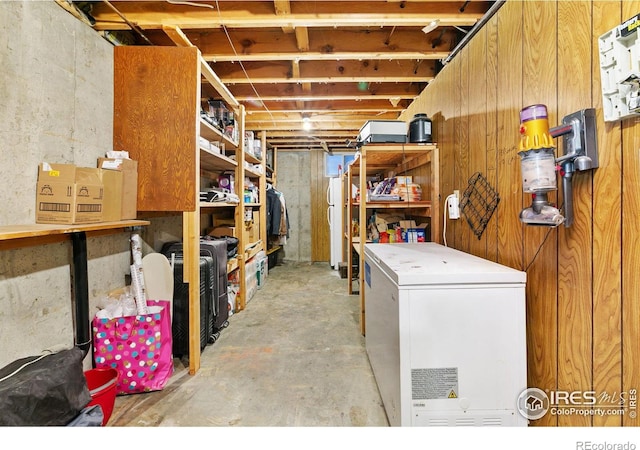 unfinished basement featuring refrigerator