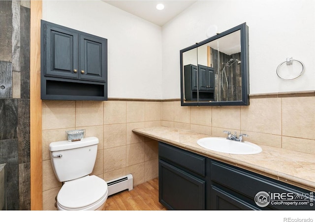 full bath featuring tile walls, a baseboard radiator, toilet, vanity, and wood finished floors