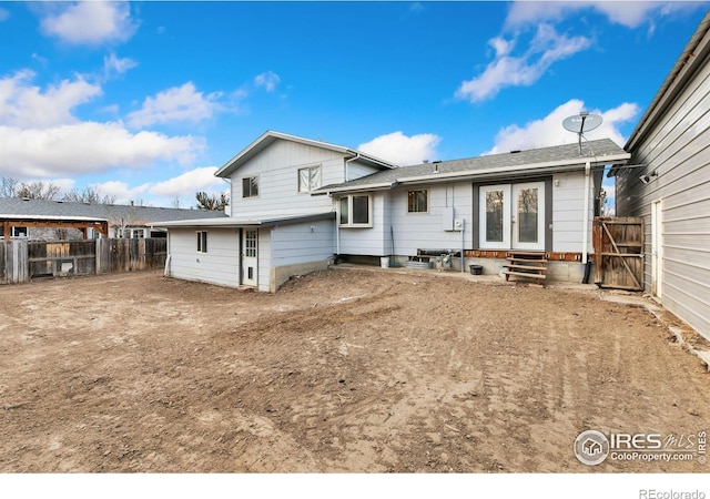 rear view of property featuring entry steps and fence