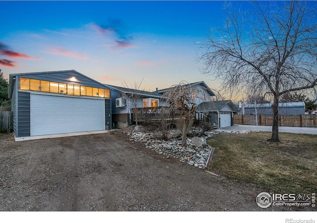 view of front of house featuring a garage, fence, and driveway