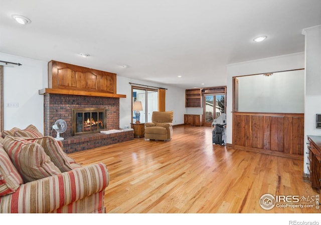 living area featuring light wood finished floors, a fireplace, and recessed lighting