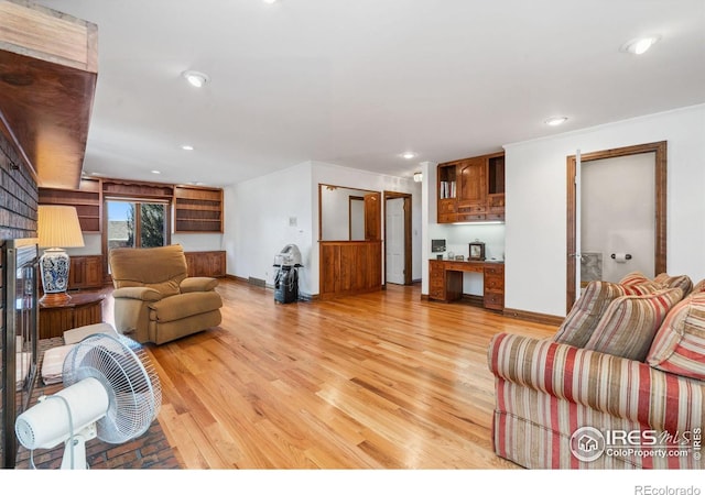 living area with baseboards, light wood finished floors, a fireplace, and recessed lighting