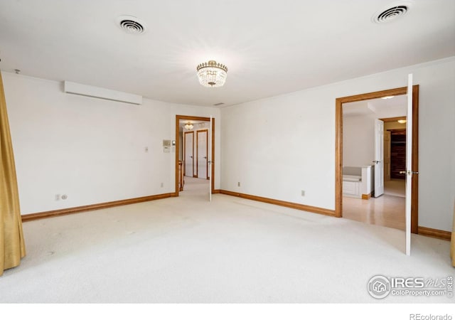 spare room featuring baseboards, visible vents, and light colored carpet