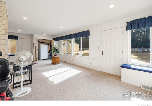 carpeted foyer featuring recessed lighting, visible vents, and baseboards