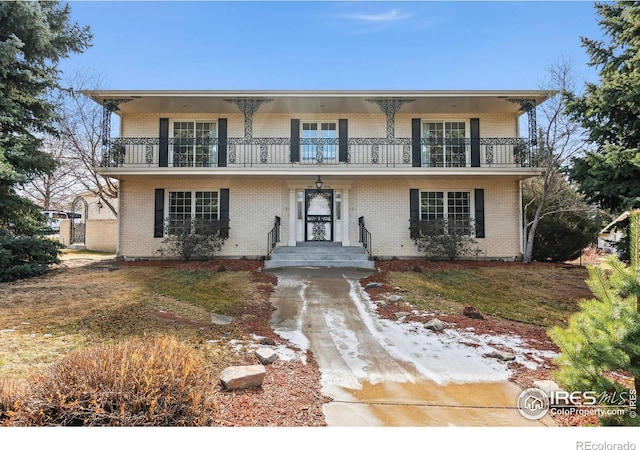 view of property featuring a balcony and brick siding