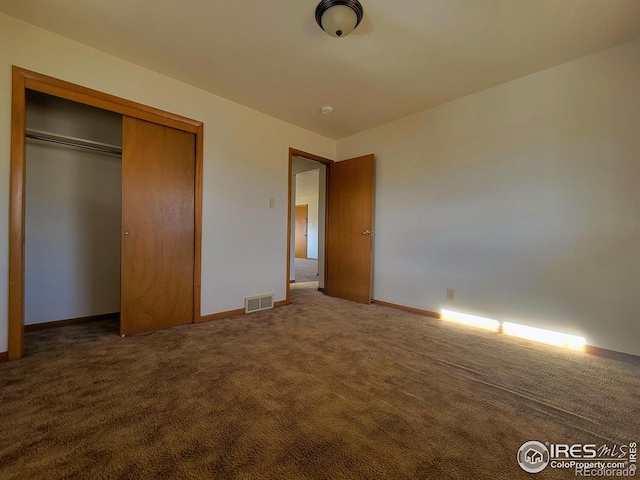 unfurnished bedroom with carpet floors, a closet, visible vents, and baseboards