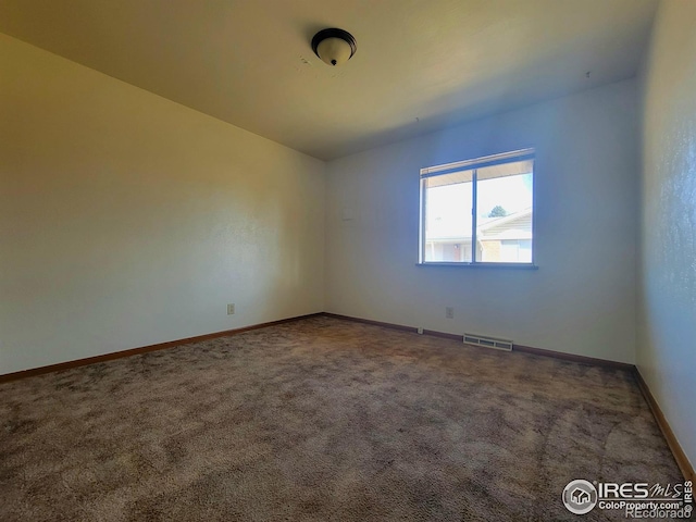 carpeted empty room featuring baseboards and visible vents