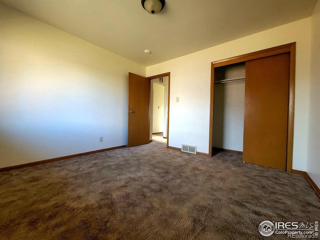 unfurnished bedroom featuring carpet, a closet, visible vents, and baseboards