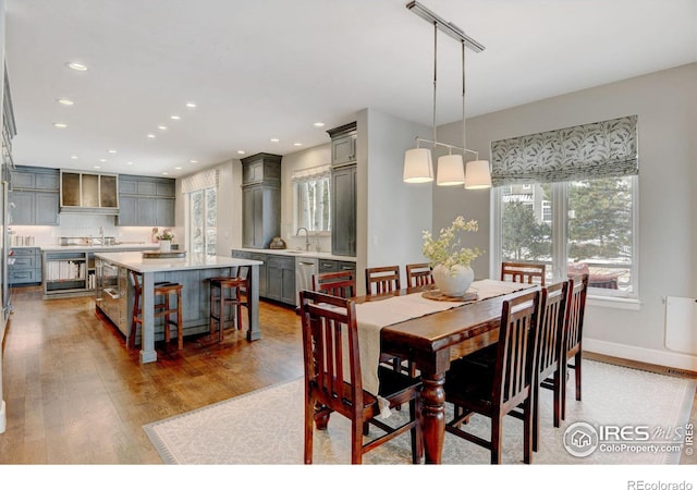 dining area featuring light wood-style floors, wine cooler, baseboards, and recessed lighting