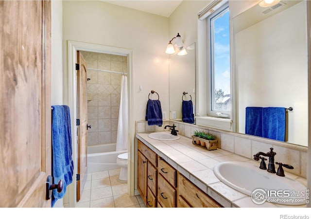 bathroom featuring tile patterned flooring, visible vents, a sink, and double vanity