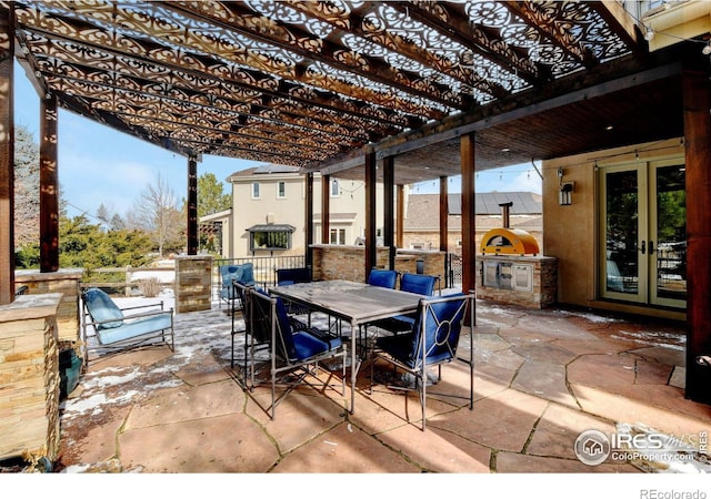 view of patio featuring exterior kitchen, outdoor dining space, french doors, and a pergola