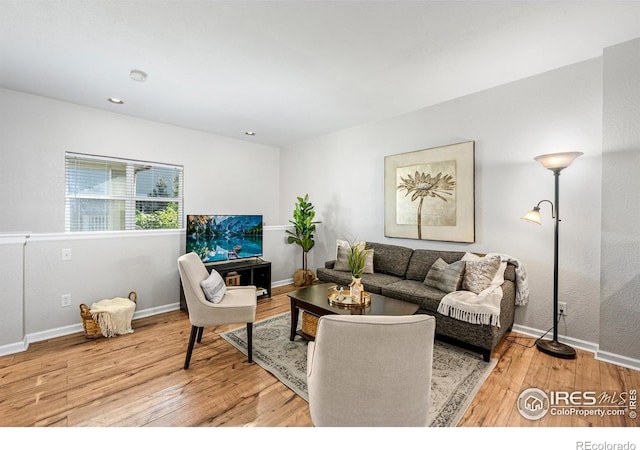 living area featuring light wood finished floors, baseboards, and recessed lighting