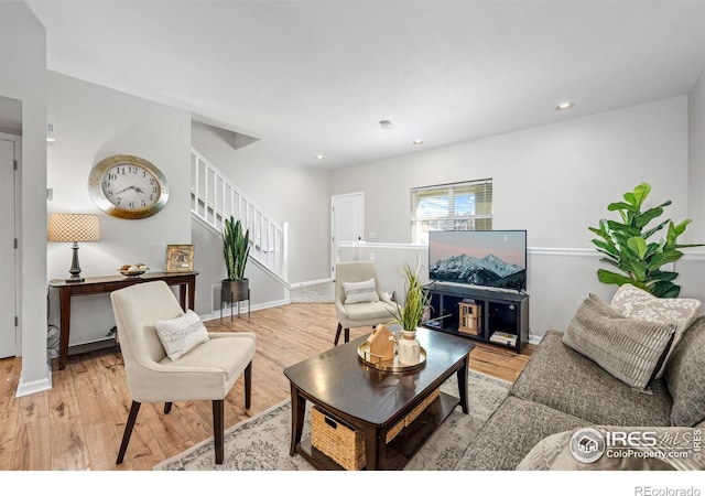 living room with light wood-type flooring, stairway, baseboards, and recessed lighting