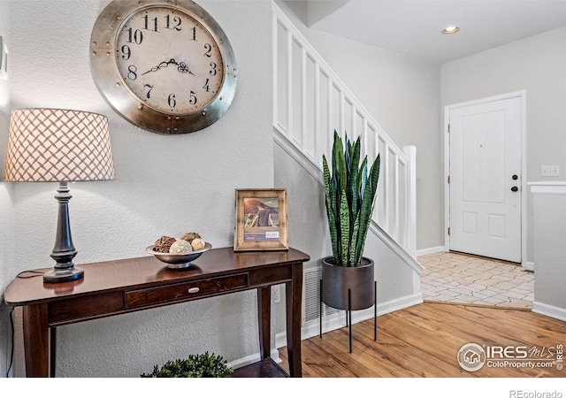 interior space with stairway, recessed lighting, wood finished floors, and baseboards