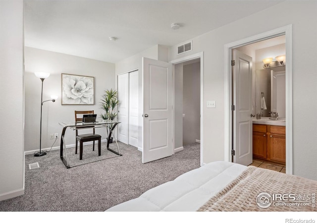 bedroom with carpet, a closet, visible vents, connected bathroom, and baseboards