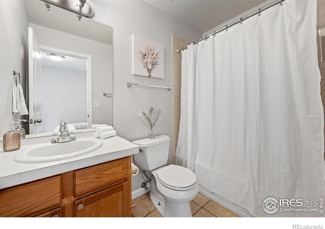 bathroom with curtained shower, vanity, toilet, and tile patterned floors