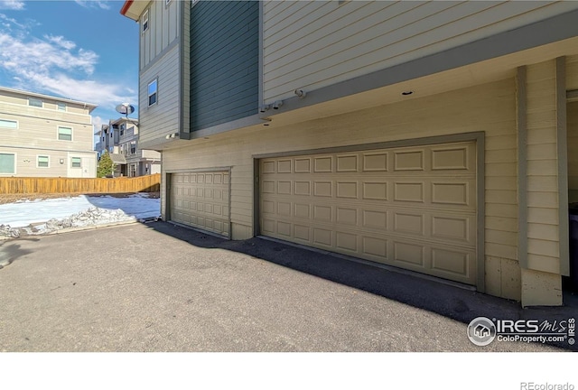 garage with driveway and fence